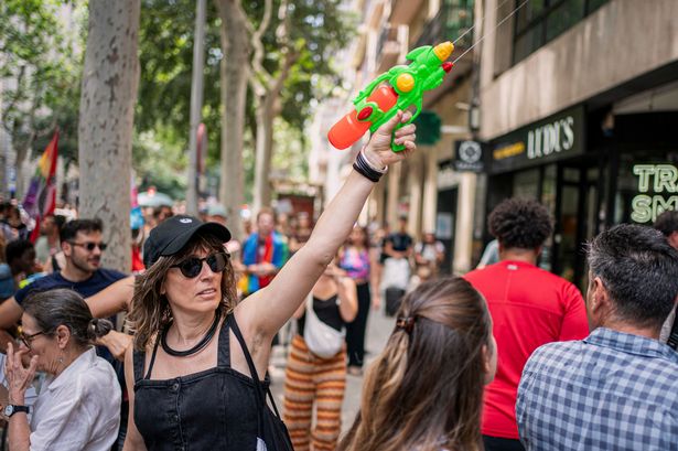 متظاهر يحمل مسدسًا مائيًا أثناء احتجاج ضد الاضطرابات في برشلونة ، إسبانيا