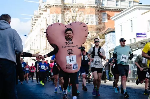 توبي فريمان ، الرئيس التنفيذي لشركة Robin Cancer Trust ، يدير ماراثون في زي يصور زوجًا عملاقًا من الخصيتين
