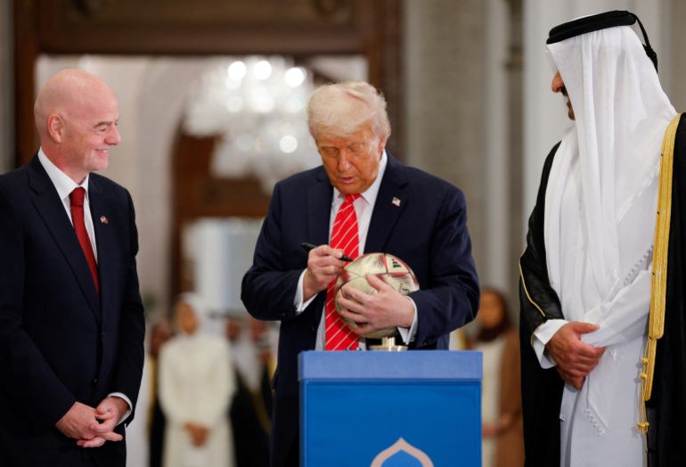 يكتب الرئيس الأمريكي دونالد ترامب على كرة كرة قدم وهو يحضر حدثًا مع إيمير تريم بن حمد آل ثاني ورئيس FIFA جياني إنفانتينو ، في Lusail Palace في Lusail ، قطر ، 14 مايو 2025.