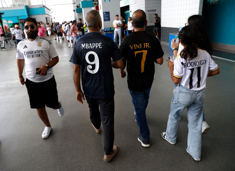 كرة القدم لكرة القدم - كأس العالم للنادي FIFA - المجموعة H - ريال مدريد ضد هيلال - استاد هارد روك ، ميامي جاردنز ، فلوريدا ، الولايات المتحدة - 18 يونيو ، 2025 مشجعين يرتدون قمصان متماثلة من ريال مدريد كايليان مبابي ، فينيسيوس جونيور ورودوريغو قبل المباراة رويترز/ماركو بيلو
