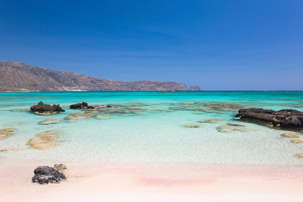 عرض عبر المياه الصافية في الخليج فيروليا من Sandy Beach ، Elafonisi Islet ، Elafonisi (المعروف أيضًا باسم Elafonissi) ، هانيا (المعروفة أيضًا باسم Chania) ، Crete ، اليونان ، أوروبا. تشتهر Elafonisi بشواطئها المذهلة من الرمال الوردية الجميلة ، على البحر الليبي في الطرف الجنوبي الغربي للجزيرة.