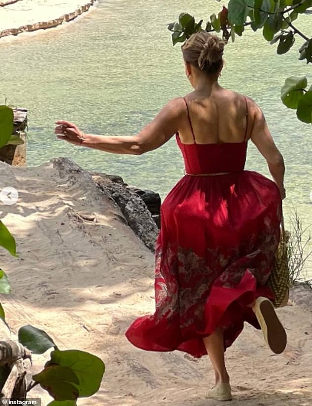 يمكن رؤية المغني وهو يركض على الرمال بالقرب من مياه ضحلة أثناء ارتداء شماس أحمر في صورة أخرى