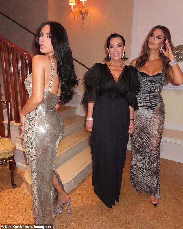 وضع Khloe على شاشة أنيقة يرتدي فستانًا مجهزًا مع قواطع صغيرة على المواد وخط العنق المنخفض