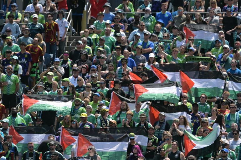 يحتفظ مشجعو سياتل ساوندرز بأعلام فلسطينية خلال مباراة كرة القدم في كأس العالم 2025 في فايفا نادي 2025 بين الولايات المتحدة في سياتل ساوندرز وفرنسا باريس سان جيرمان في ملعب لومن فيلد في سياتل في 23 يونيو 2025.