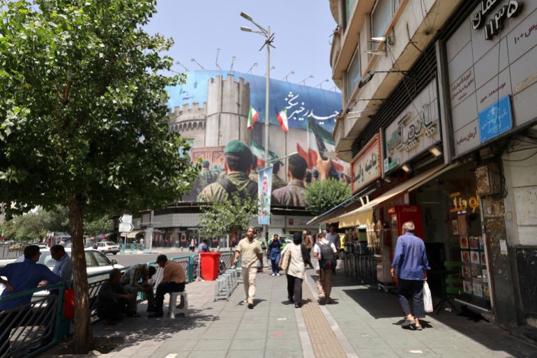 المشي الإيراني على طول شارع في ميدان Enghelab (Revolution) ، في طهران في 24 يونيو 2025. قالت وسائل الإعلام الإيرانية في 24 يونيو ، وهي ضربة إسرائيلية في شمال البلاد قتلت تسعة أشخاص ، قبل إعلان الرئيس الأمريكي عن بداية إطلاق النار بين إسرائيل وإيران. (تصوير Atta Kenare / AFP)