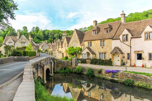 منظر خلاب من المنازل الريفية مع جدران حجرية كوتسوولد في Castle Combe ، Cotswolds ، إنجلترا