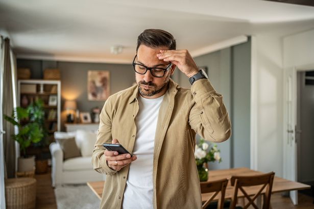 يشعر شاب بالاكتئاب والتفكير في الأخبار السيئة التي يقرأها عبر الإنترنت من خلال هاتفه الذكي