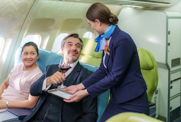 شركة طيران Air Hostess Amstract في طائرة تقدم النبيذ الأحمر لرجل الأعمال