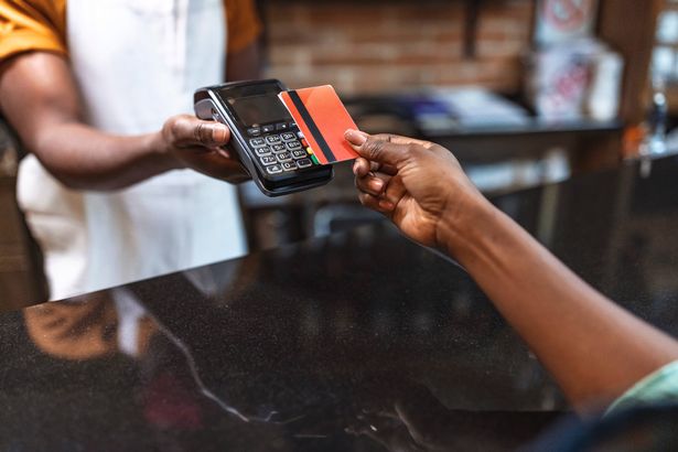 تقنية NFC. عن قرب من الإناث السوداء ، مع إعطاء بطاقة الائتمان للنادل يدفع مع بطاقة ائتمان حمراء في المقهى