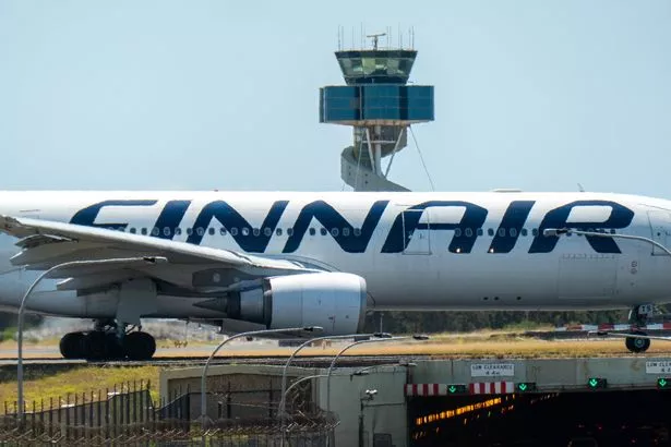 طائرة Finnair Airbus A330-302 ، التسجيل OH-LTS ، تاكسي إلى الطرف الجنوبي من المدرج الرئيسي للمغادرة من مطار سيدني Kingsford Smith كطيران QF291 إلى سنغافورة. في الخلفية في برج مراقبة الحركة الجوية. في المقدمة يوجد النفق تحت ممرات الأجرة والمدرج الرئيسي. تم التقاط هذه الصورة من شارع Kyeemagh ، Kyeemagh في صباح حار ومشمس في 4 يناير 2025.