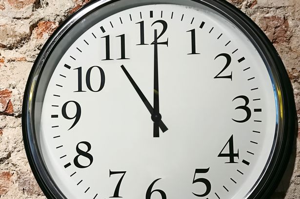 ساعة تظهر الساعة 11 ، على جدار من الطوب