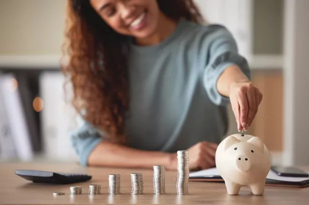 امرأة شابة أموال تضع العملات المعدنية في بنك الخنزير في المنزل
