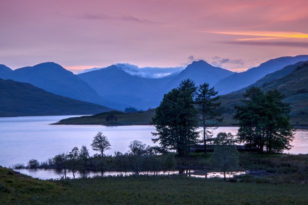 الضوء الأخير من اليوم يضيء السماء فوق Loch Arklet المطلة على Ben Vorlich & Ben Ime في حديقة Loch Lomond & Trossachs الوطنية ، اسكتلندا ، 20 أغسطس 2018.