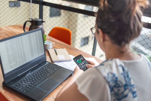 امرأة ناضجة تقوم بالتمويل من خلال تطبيق الجوال المصرفي. على الكتفين عرض.