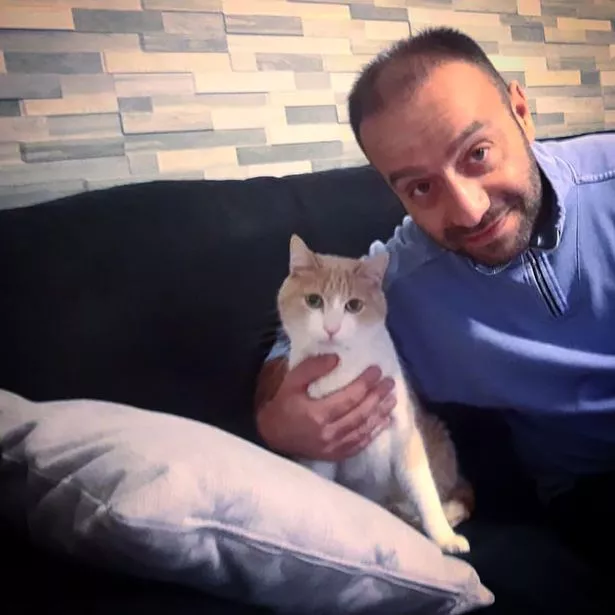 رجل على أريكة يحمل قطة 