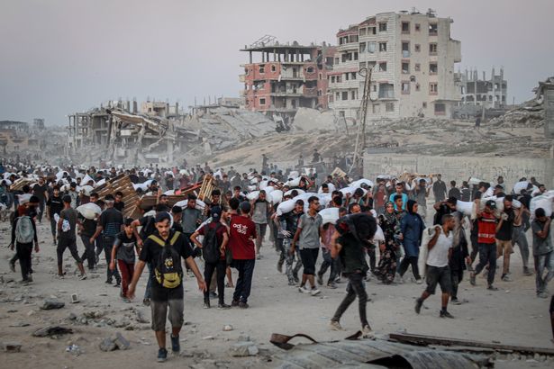 الفلسطينيون الذين يحملون المساعدات المكتسبة في معبر زيكيم