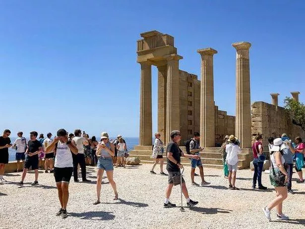 الناس الذين يزورون الأكروبوليس في ليندوس في جزيرة رودس اليونانية