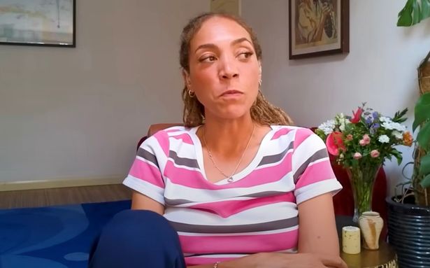 جلس ميكيتا أوليفر ، في سراويل مخططة وزرقاء ، يسجل بودكاست.
