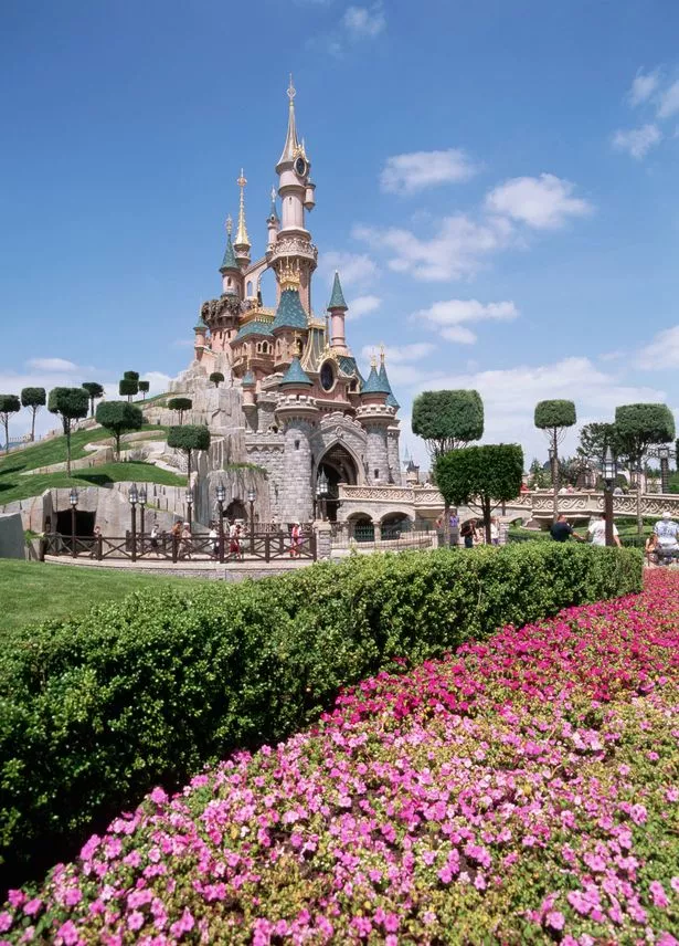 تزين الأشجار والزهور الأراضي حول قلعة Sleeping Beauty في Fantasyland في Euro Disneyland ، بالقرب من باريس ، فرنسا