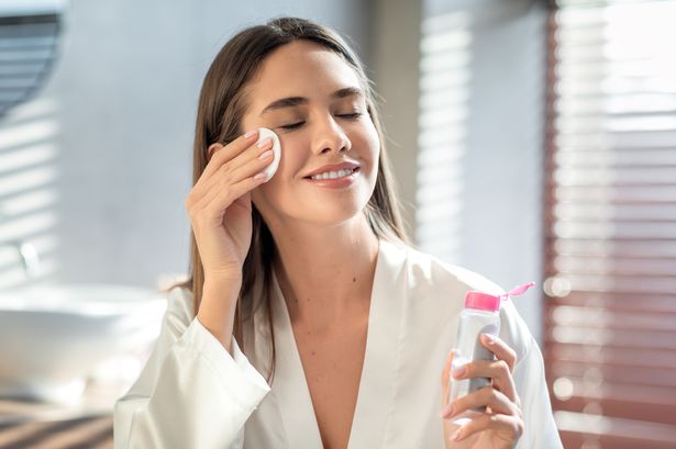 صورة لامرأة شابة تستخدم ماء micellar لتنظيف وجهها