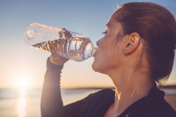 امرأة تشرب المياه المعبأة