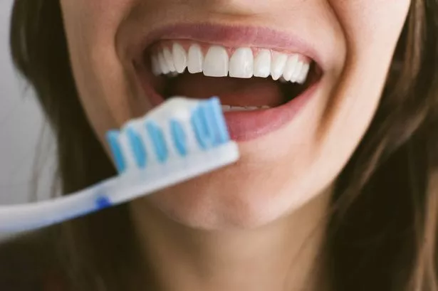 امرأة شابة تفرش الأسنان