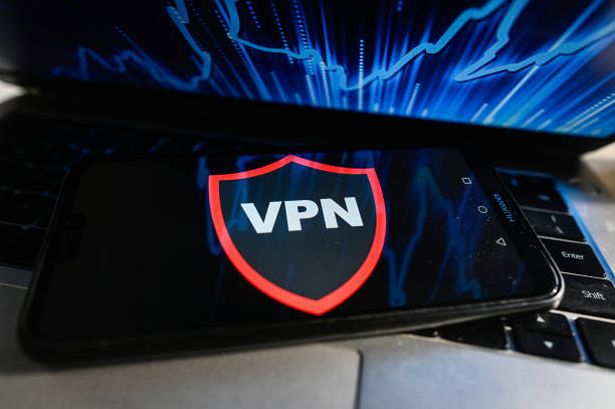 يتم عرض شعار VPN على هاتف ذكي مع نسب سوق الأوراق المالية في الخلفية.