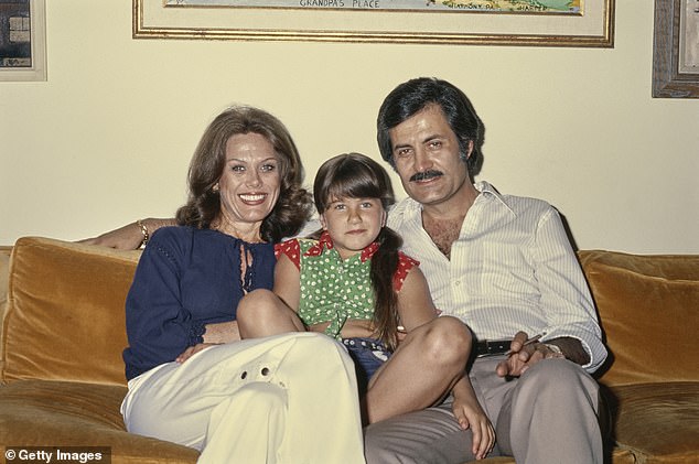 أنيستون بصفتها طفلة في السادسة من عمرها مع والديها نانسي وجون في عام 1975. وفقًا لمصدر واحد ، كانت والدتها تشعر بالغيرة دائمًا من أن جين حققت مستوى النجاح الذي لم تفعله أبدًا