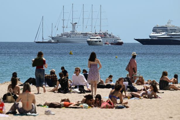 يستمتع Beachogoers بالشمس على شاطئ على طول شارع De La Croisette ، حيث يجلس اليخوت وسفن الرحلات البحرية قبالة الشاطئ ، على هامش الطبعة 78 من مهرجان مهرجان كان في مهرجان ماجير ، جنوب فرنسا ، في 17 مايو ، 2025.