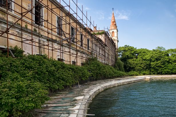 يكمن مبنى مدمر في انهيار جزيرة Poveglia المهجورة والمسكون به في إيطاليا.