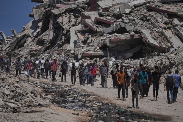 يحمل الفلسطينيون أكياس من المساعدات الإنسانية التي تم تفريغها من قافلة الشاحنات التي كانت تتجه إلى مدينة غزة ، في قطاع غزة الشمالي الأحد ، 20 يوليو 2025