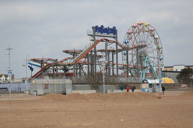 يمشي الناس عبر الملاهي المغلقة على الجبهة على الشاطئ في Skegness ، لينكولنشاير ، خلال القفل الوطني الثالث في إنجلترا للحد من انتشار فيروس كوروناف. تاريخ الصورة: الثلاثاء 23 مارس 2021. PA Photo. انظر PA Story Health Coronavirus. يجب أن تقرأ الائتمان الصورة: مايك إيغرتون/سلك