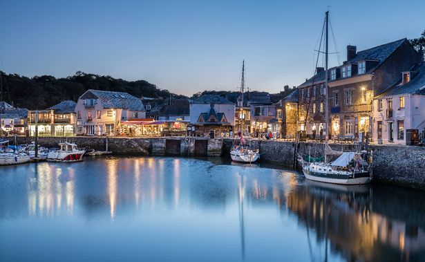 Padstow Harbour في Blue Hour ، Cornwall ، مع انعكاسات القوارب والأضواء داخل الحافلة وحولها.