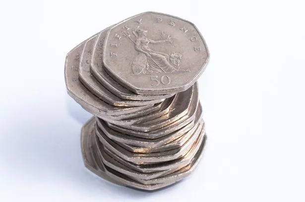 كومة من خمسين قطعة نقدية على خلفية بيضاء.