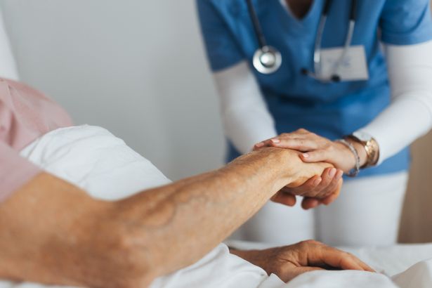 الدعم من ممرضة إلى مريض ، رعاية رجل مسن في المستشفى. 