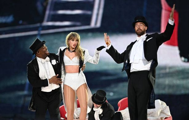 تم ربط Taylor Swift على المسرح بواسطة Travis Kelce (R) ، خلال "تايلور سويفت | جولة العصور"