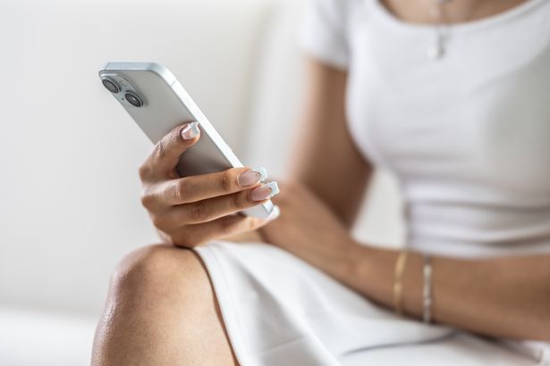 امرأة تستخدم iPhone أثناء جلستها