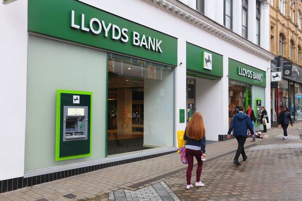 الناس يمشون من قبل بنك لويدز في ليدز ، المملكة المتحدة. Lloyds Bank هو شركة محدودة عامة وهي واحدة من أكبر البنوك في المملكة المتحدة.