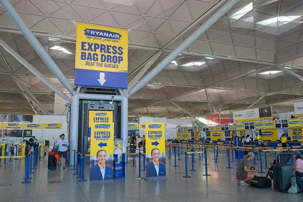 لندن ، المملكة المتحدة - 12 يوليو 2025: يسجل الركاب في منطقة Express Bag Drop في شركة طيران ميزانية في مطار ستانستيد ، لندن