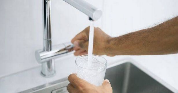 رجل يملأ كوب من الماء