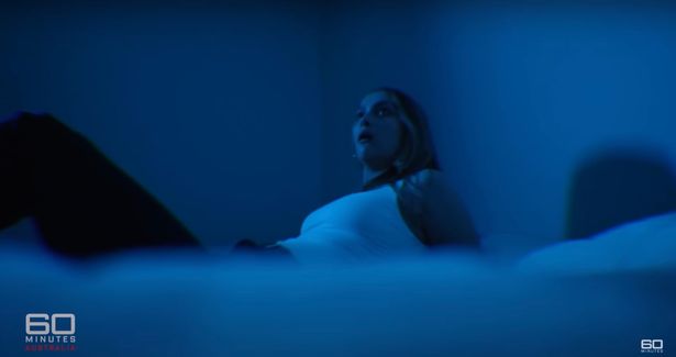 امرأة على سرير تبدو خائفة على سرير في إعادة تشريع فيلم وثائقي