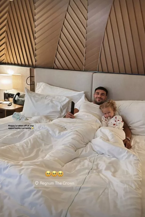 تومي فيوري وبامبي في سرير في غرفة الفندق في عطلة.