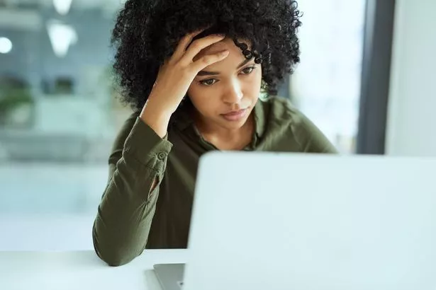 لقطة لسيدة أعمال شابة تبدو متوترة أثناء استخدام جهاز كمبيوتر محمول في مكتب حديث
