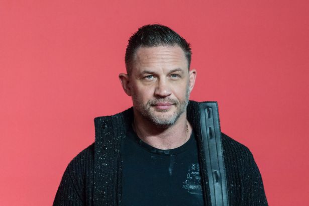 توم هاردي ، في قمة أسود وسترة ، على سجادة حمراء في أكتوبر 2024.