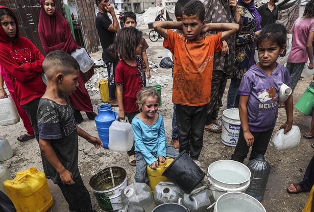 الفلسطينيون ، بمن فيهم الأطفال ، ينتظرون في طابور لملء علب المياه