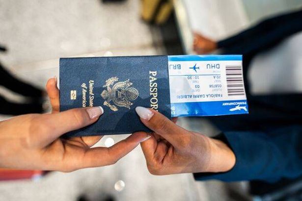 امرأة تعطي جواز سفرها لمضيفة طيران في المطار