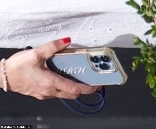 رفيقة أنثى مسمر صيف أنيقة في لباس برودري أنجلايز أبيض مقترن بمتسكعون للطباعة ، في حين أن قضية الهاتف مبللة بالأحرف الأولى من الموارد البشرية 