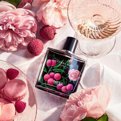 زجاجة من عش Lychee وردة ملقاة على طاولة بجوار الزهور والطعام