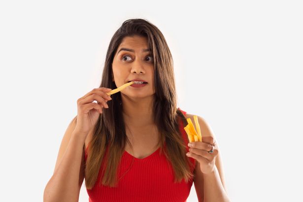 امرأة تأكل البطاطس المقلية