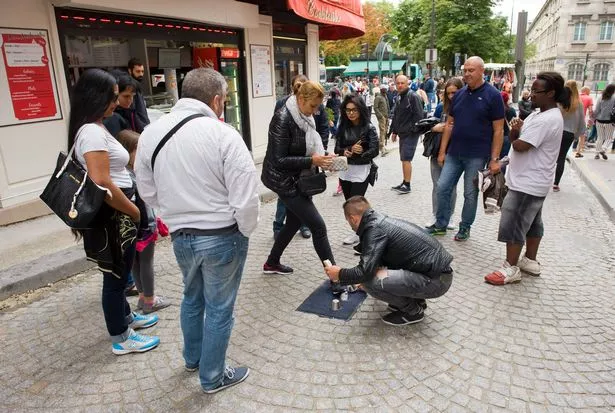باريس ، فرنسا - 27 يوليو 2015: رجل يلعب لعبة خدعة مسرقة ما هو غير قانوني في شارع في باريس في فرنسا
